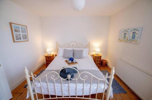 a bedroom with a white bed with two lamps at The Sovereign in Whitstable