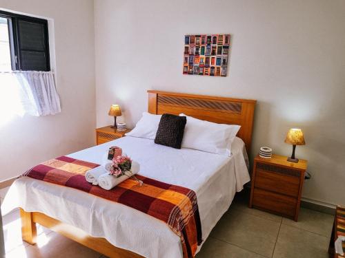 a bedroom with a bed with flowers on it at Ao lado da Igreja Matriz, Hospedagem de Charme in Santa Rita do Sapucaí