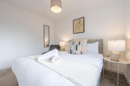 a bedroom with a white bed and a table at Stylish 3BED Glan Llyn Retreat - Close to Cardiff & Newport - Parking in Newport