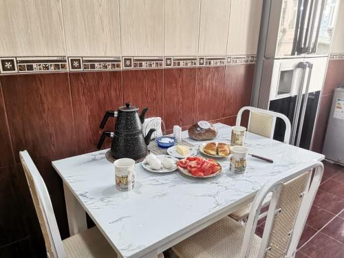 een tafel met een waterkoker en eten erop bij Baku Hostel in Baku