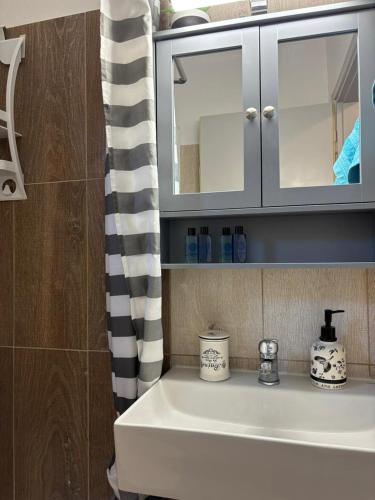 a bathroom with a sink and a shower curtain at Nisteri Seaside in Limenas