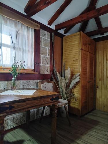 a room with a wooden table and a window at Flowers Cabin in Valjevo