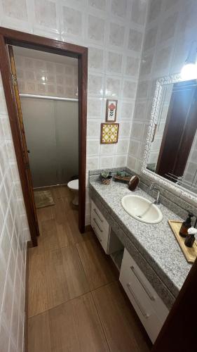 a bathroom with a sink and a toilet and a mirror at Casa ampla próxima à Rua do Lazer in Santa Teresa
