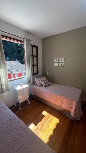 a bedroom with two beds and a window at Casa ampla próxima à Rua do Lazer in Santa Teresa