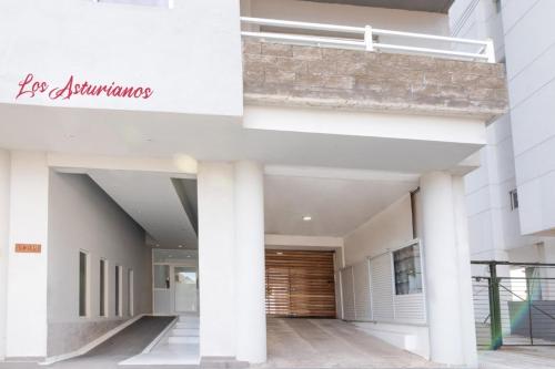 a white building with columns and a sign on it at Asturiano 6 Miramar in Miramar