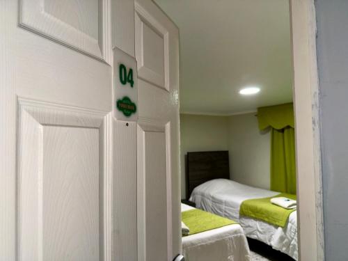 a room with two beds and a door to a bedroom at Hotel Boutique Parque Brasil in Antofagasta