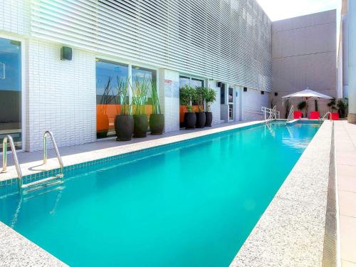 a swimming pool with blue water in a building at Novotel Santos Gonzaga in Santos