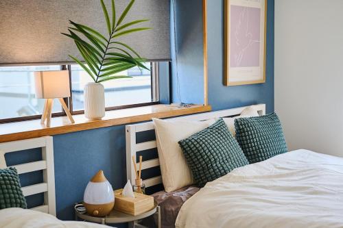a bedroom with two beds and a window and a plant at IZUMI House in Yachimata
