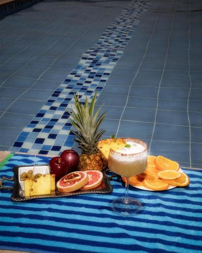 a tray of fruit and a drink next to a pool at Hotel Bella Isa in La Dorada