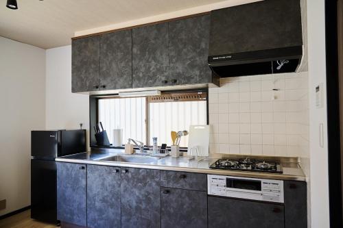 a kitchen with a sink and a stove at IZUMI House in Yachimata