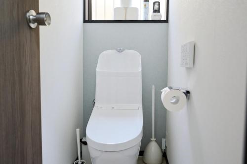a bathroom with a white toilet and a roll of toilet paper at IZUMI HOUSE - 成田空港から車で22分 - 最大8名 - 駐車場2台完備 - Switch有 - 10月28日以降ペット歓迎 in Yachimata