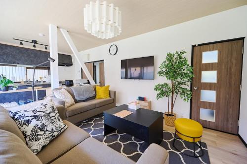 a living room with a couch and a table at IZUMI House in Yachimata