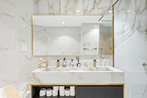 a white bathroom with a sink and a mirror at 2BDR Luxury Apartment in Palm in Dubai