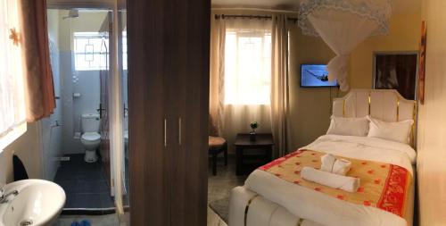 een slaapkamer met een groot bed en een badkamer bij Atlantis City BnB in Nakuru