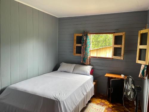 a small bedroom with a bed and a window at Casas Salomão in Santo António