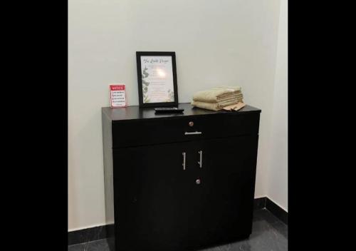 a black dresser with a picture on top of it at Samuels Comfort Homes in Bengaluru