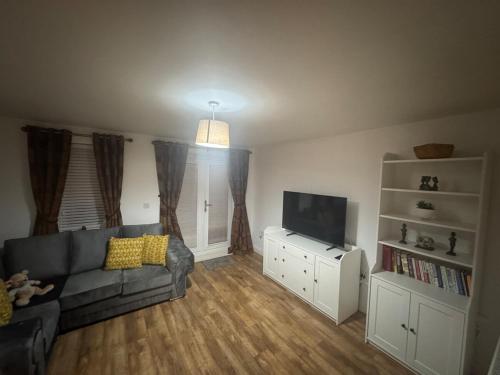 a living room with a couch and a flat screen tv at Two bed Ideal newport base in Newport