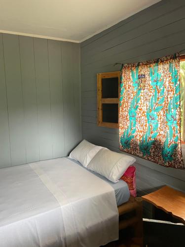 a bedroom with two beds and a window at Casas Salomão in Santo António