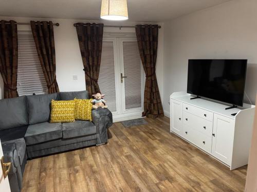 a living room with a couch and a flat screen tv at Two bed Ideal newport base in Newport