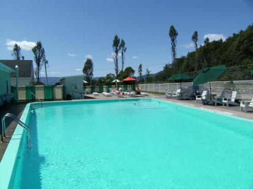 a large swimming pool with blue water at Hotel-Motel Les Voitures d'Eau in L'Isle-aux-Coudres