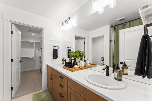 Un baño con dos lavabos y un espejo grande. en Modern Boise Luxury Retreat, en Boise