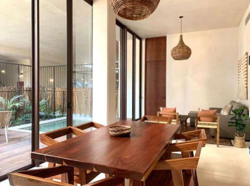 Una sala de estar con una mesa y sillas de madera. en Charming 2BR Ground Floor with Private Pool, en Tulum