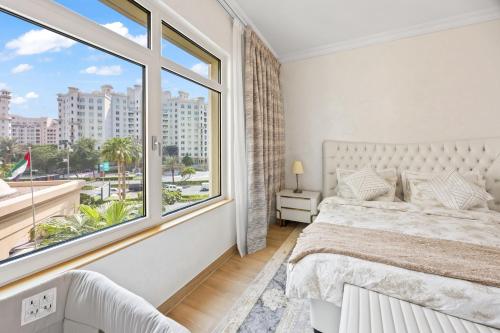 a bedroom with a bed and a large window at 2BDR Luxury Apartment in Palm in Dubai