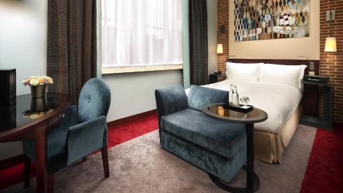 a hotel room with a bed and a chair at Sofitel Legend The Grand Amsterdam in Amsterdam
