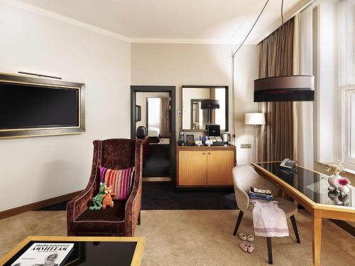 a hotel room with a chair and a desk at Sofitel Legend The Grand Amsterdam in Amsterdam
