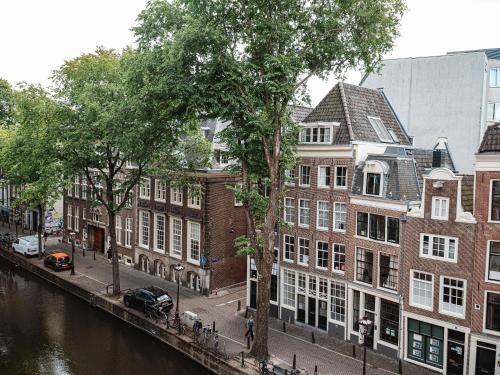 a group of buildings on a street next to a river at Sofitel Legend The Grand Amsterdam in Amsterdam