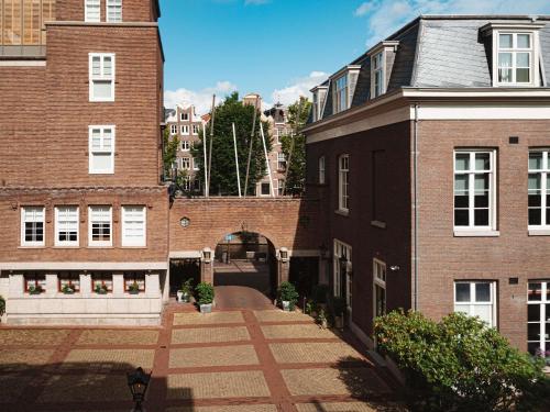 an alley between two brick buildings with an archway at Sofitel Legend The Grand Amsterdam in Amsterdam