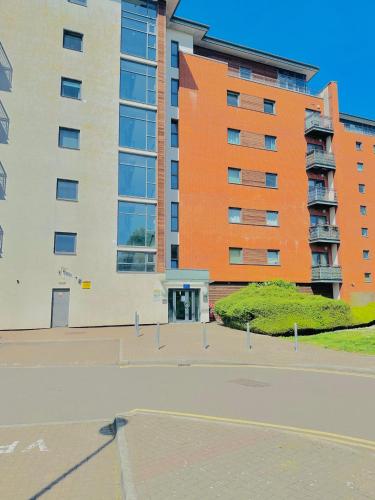 an orange and white building in front of a street at Spacious Room in Cardiff Bay Apartment with Private Bathroom in Cardiff