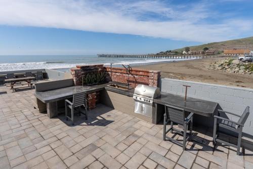 a patio with a table and a grill and the beach at Shoreline Inn...on the beach in Cayucos