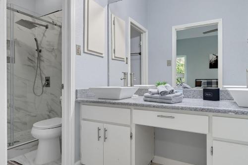 Un baño blanco con dos lavabos y una ducha. en Luxury vacation house with Private Pool & Jaccuzi Close to SeaWorld Alamo and River Walk, en San Antonio