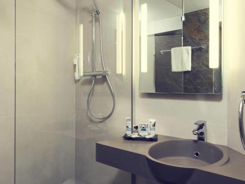 a bathroom with a sink and a shower at Mercure Paris Porte de Pantin in Pantin