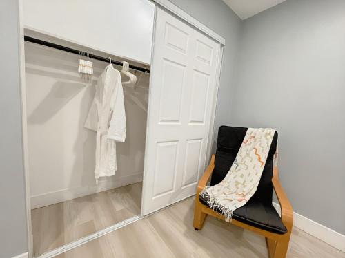 a walk in closet with a white door and a chair at Comfort Meets Convenience in Schaumburg