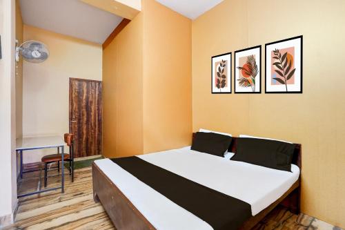 a bedroom with a bed and a desk in it at Hotel O Euphoria inn in Morādābād