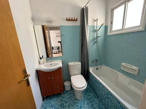 a bathroom with a toilet and a sink and a tub at Spacious City Center - Suite 203 in Nicosia