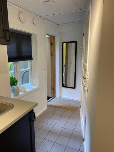 a kitchen with a sink and a door with a mirror at Studioleilighet midt i Trondheim in Lii