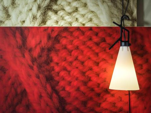 a red wall with a lamp attached to it at Ibis Sheffield City in Sheffield