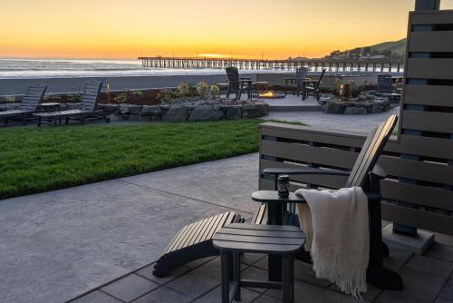 a bench and a table and chairs at the beach at Shoreline Inn...on the beach in Cayucos