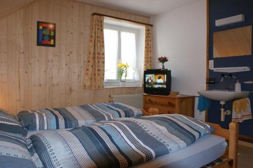 a bedroom with two beds and a sink and a window at Gasthaus Waldheim in Fürstenaubruck