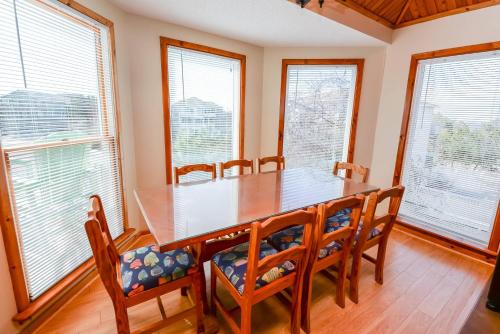 a dining room with a table and chairs and windows at Shore Is Fun in Duck