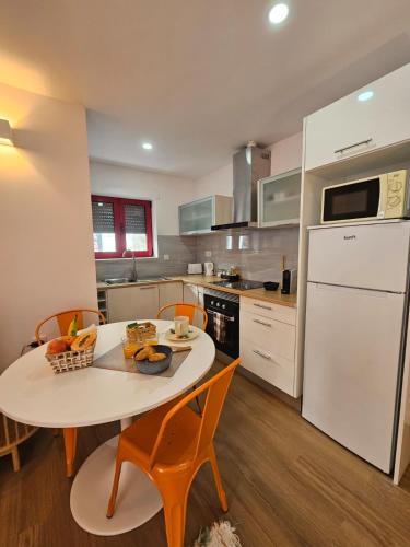 a kitchen with a table and chairs and a white refrigerator at Vila Real Central House in Vila Real