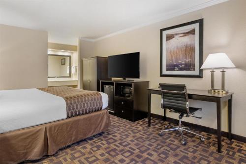 a hotel room with a bed and a desk with a computer at Best Western PLUS Inn of Hayward in Hayward