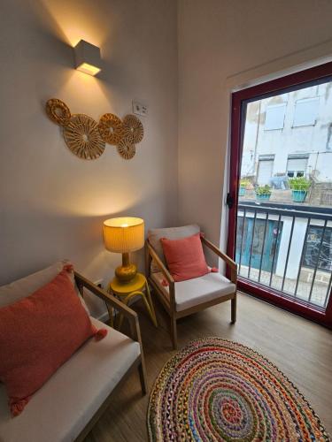 a living room with a couch and a chair and a window at Vila Real Central House in Vila Real