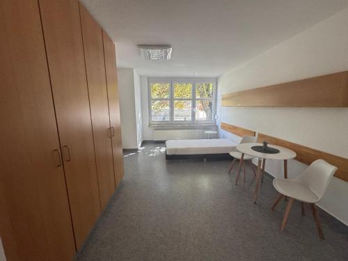 a room with a bed and a table and chairs at Gemütliche Monteurswohnungen voll möbliert & Zentral in Nentershausen