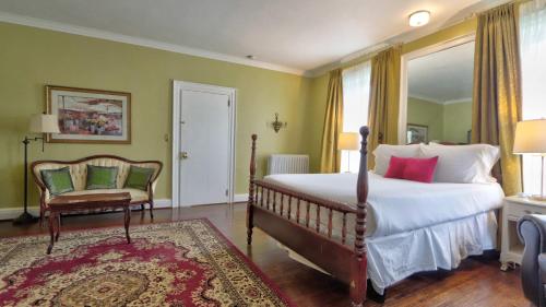a bedroom with a bed and a chair and a window at Historic 98 Fire Pit Game Room & Dog Friendly in Geneva