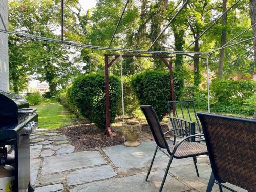a patio with two chairs and a swing at Historic 98 Fire Pit Game Room & Dog Friendly in Geneva
