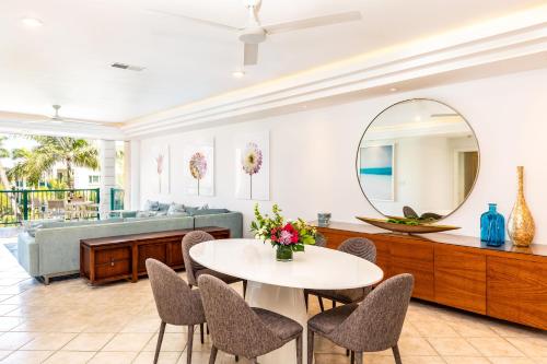 a living room with a table and chairs and a mirror at 2 Bdrm Pool Marina View at The Yacht Club E12 in Providenciales